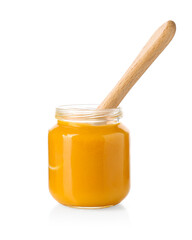 Baby food. Tasty puree in glass jar and spoon isolated on white
