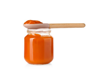 Baby food. Tasty puree in glass jar and spoon isolated on white