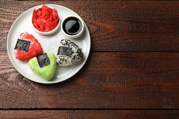 Tasty tobiko onigiri (Japanese rice balls) served on wooden table, top view