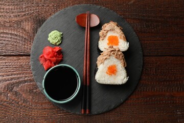 Tasty onigiri (Japanese rice balls) with tuna served on wooden table, top view
