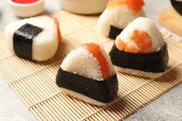 Tasty onigiri (Japanese rice balls) served on light table, closeup
