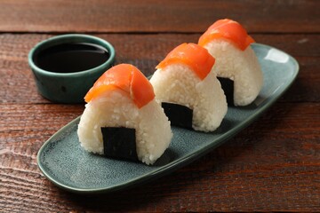 Tasty onigiri (Japanese rice balls) served on wooden table, closeup