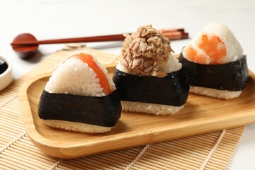 Tasty onigiri (Japanese rice balls) served on white table, closeup