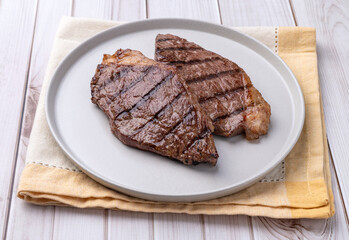Grilled picanha beefs in a plate over wooden table
