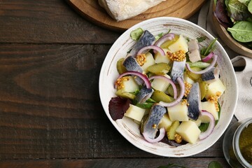 Delicious salad with herring and vegetables served on wooden table, flat lay. Space for text