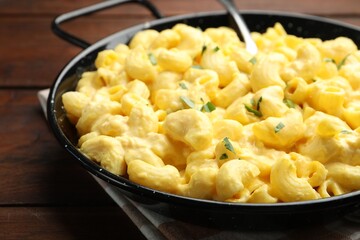 Delicious pasta with cheese sauce on wooden table, closeup