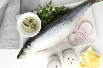 Salted herring and spices on white table, flat lay