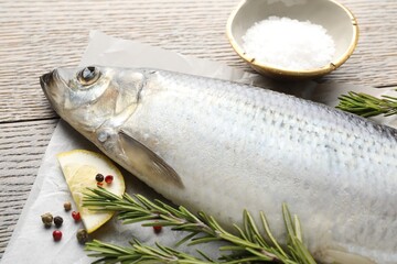 Salted herring and spices on wooden table, closeup