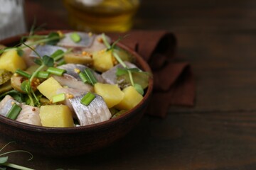 Delicious salad with herring on wooden table, closeup