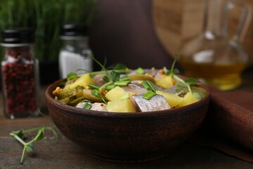 Delicious salad with herring on wooden table, closeup