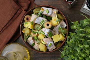 Delicious salad with herring on wooden table, flat lay