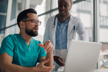 Medical professionals collaborating on patient care using laptop