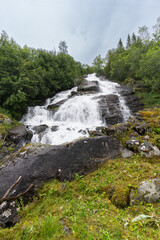 Holebroa waterfall over Geiranger village in More og Romsdal county, in Stranda municipality western Norway surrounded by unspoiled lush