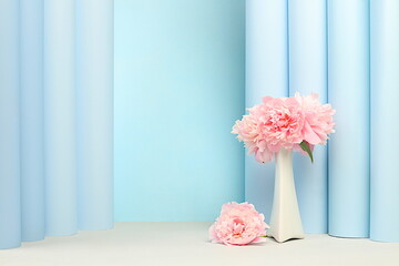 Abstract floral arrangement with delicate peonies and roses flowers in vase on elegant modern background.Spring still life and banner for screen,empty podium for product display,beauty concept.