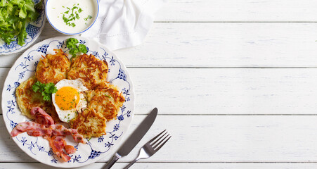 Potato Cakes. Vegetable fritters, latkes, hash browns. Vegetable pancakes with fried egg and bacon. High angle view with copy space