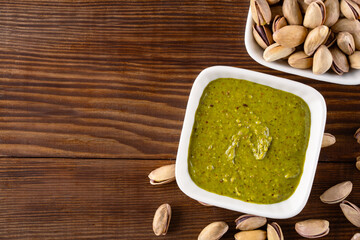 Delicious pistachio butter on wooden background