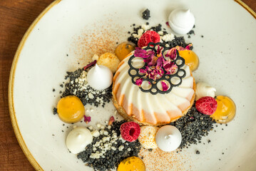 Gourmet plated dessert with raspberries and edible flowers
