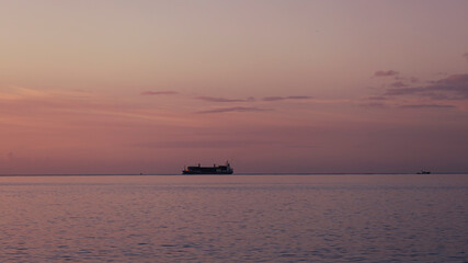 Soft pink light at dawn, ship in ocean, Lanzarote