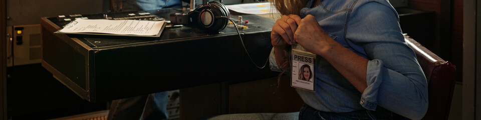 Header of young reporter or journalist pinning badge on shirt while preparing for shooting news...