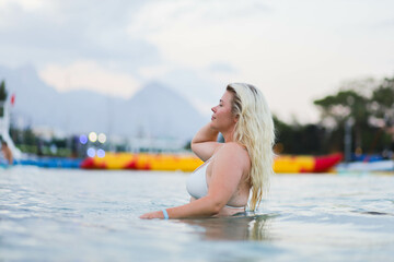 blonde woman on vacation in the sea in the water in the mountains