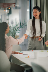 Obraz premium Businesswomen shaking hands in modern office setting