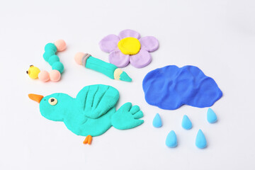 Different colorful child's crafts made of play dough on grey background, closeup