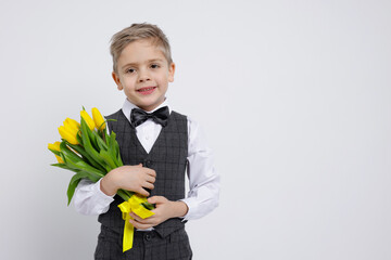 Cute little boy with bouquet of tulips on white background. Space for text
