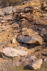 View of the stone cliff of a granite quarry. Large stones. Stone layers.