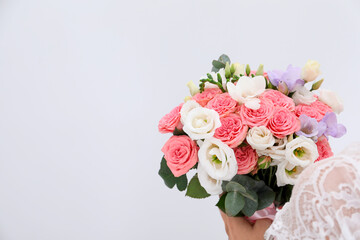 Bride with beautiful wedding bouquet on light background, closeup. Space for text