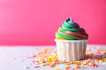 Delicious cupcake with colorful cream and confetti on light table, closeup. Space for text