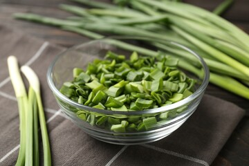 Cut fresh green onions in bowl on table, closeup