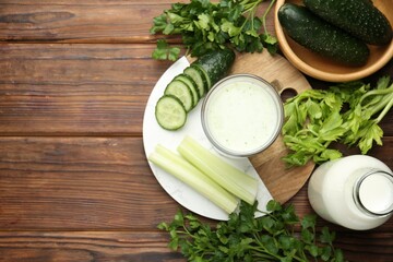 Healthy parsley drink, leaves, celery and cucumber on wooden table, flat lay. Space for text