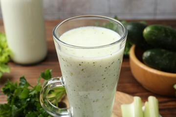 Healthy parsley drink, leaves, celery and cucumber on wooden table, closeup