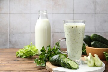 Healthy parsley drink, leaves, celery and cucumber on wooden table, closeup. Space for text