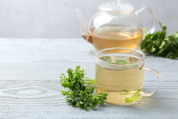 Healthy parsley tea on grey wooden table, space for text. Detox drink