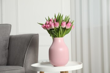 Bouquet of beautiful tulips in vase on white table indoors