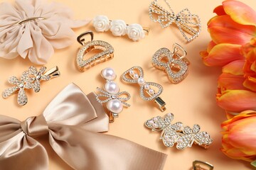 Beautiful hair clips, bow and tulips on beige background, above view
