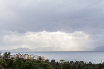A scenic view of Bodrum’s coastline in Turkey, with white houses spread across the hills and a sky filled with soft clouds.