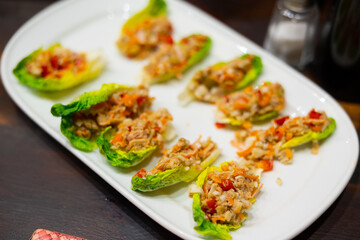 Appetizing tuna fish and vegetables in lettuce leaf served on platter