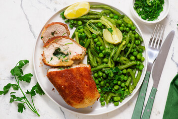 Chicken Kiev with green vegetables, peas and green beans