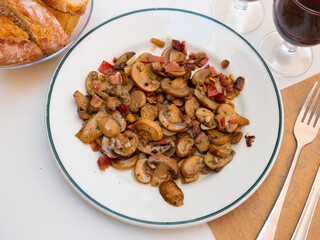 Spanish champinones salteados, roasted champignons with glass of wine in a cafe