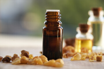 A dark bottle of frankincense essential oil with frankincense resin