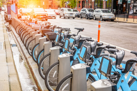Row of share-use bicycles at a docking station along a street in downtown Chicago after a spring thunderstorm
