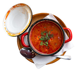 In saucepan on table there is portion of traditional Slovak dish - sauerkraut soup and fatty homemade pork sausage. Home-cooked restaurant, traditional Eastern European food. Isolated over white