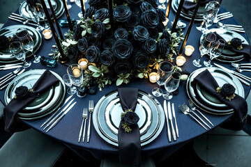 A table set for a formal dinner party with black roses and candles
