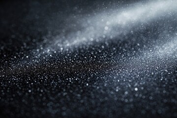 Abstract dark background with glittering silver particles and bokeh effect, creating a sparkling and magical atmosphere.