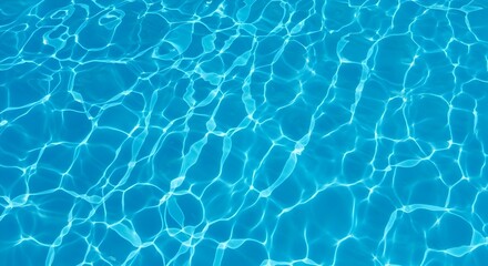 A top-down shot showing a close-up texture of clear blue water in a swimming pool or similar body of water. The sunlight creates a pattern of light and shadow on the water's surface.