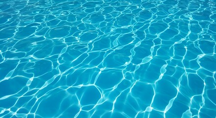 A top-down shot showing a close-up texture of clear blue water in a swimming pool or similar body of water. The sunlight creates a pattern of light and shadow on the water's surface.