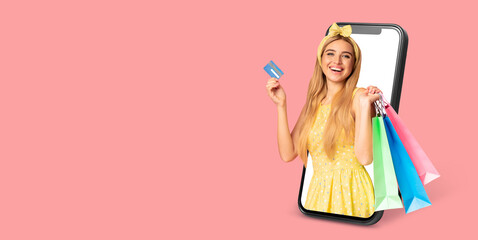 A cheerful customer is excitedly using a smartphone to shop online. She holds colorful shopping bags and a credit card, ready to make purchases. The background is simple and isolated.