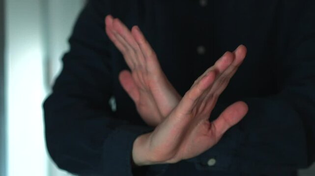 A man shows a NO gesture with his hands.
The man waves his hands and says that it is not necessary